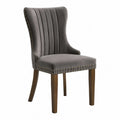 Sedia in velluto grigio con gambe in legno e borchie